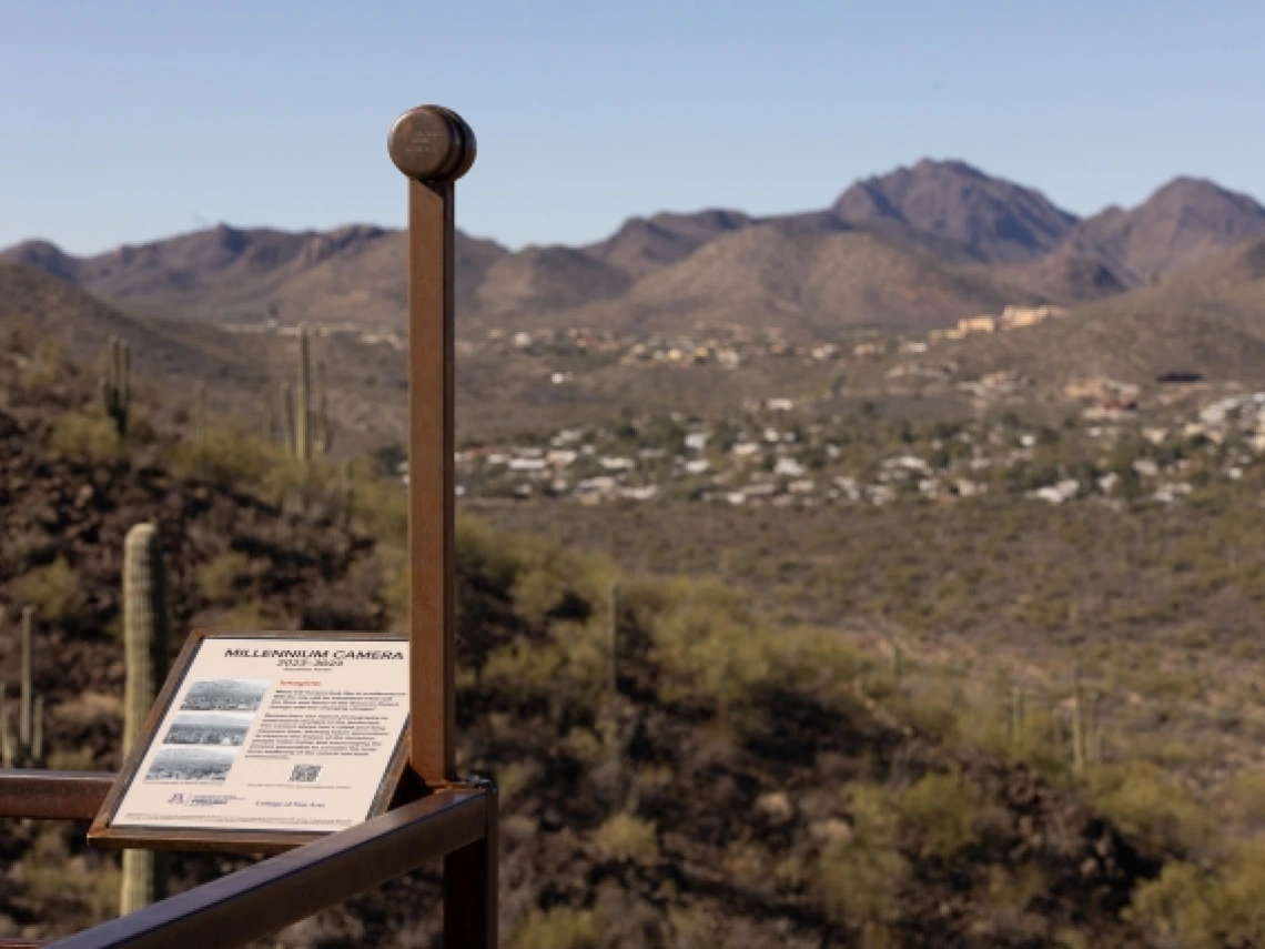 A simple pinhole camera, mounted atop a pole, looks out across a desert landscape. 