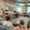 Students sit in a large circle in a campus lounge as members of the Mohamed Abozekry Sextet speak from a table at the front of the room. The musicians and professor lead a discussion about Arabic instruments and jazz fusion as part of a Contemporary Muslim Societies class.